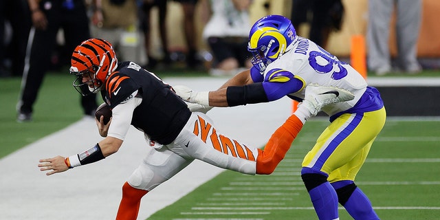 Aaron Donald #99 von den Los Angeles Rams schiebt Joe Burrow #9 von den Cincinnati Bengals im dritten Quartal während des Super Bowl LVI im Sophie Stadium am 13. Februar 2022 in Englewood, Kalifornien, heraus. 