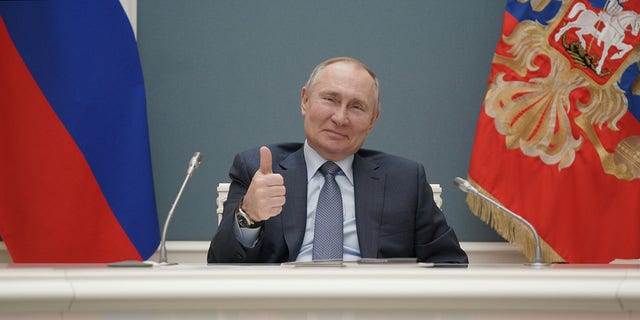 Der russische Präsident Wladimir Putin hebt den Daumen, als er am 10. März 2021 per Videoverbindung in Moskau, Russland, an einer Spatenstichfeier für den dritten Reaktor des Kernkraftwerks Akkuyu in der Türkei teilnimmt.