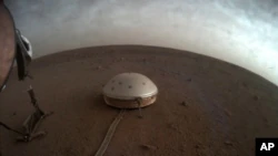In diesem undatierten Bild, das am Donnerstag, den 22. Juli 2021 von der NASA zur Verfügung gestellt wurde, ziehen Wolken über das kuppelbedeckte SEIS-Seismometer des InSight-Landers auf dem Mars.