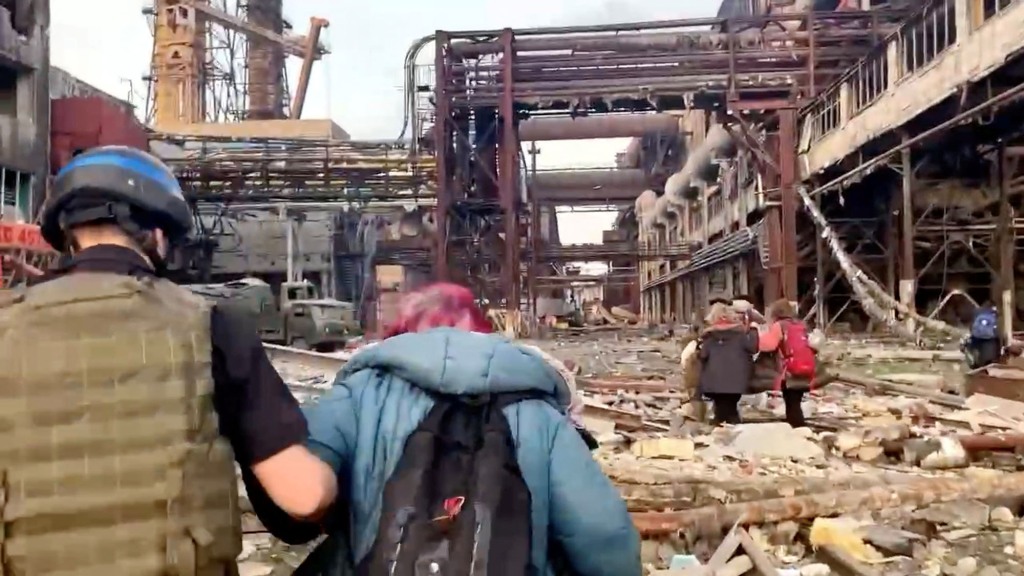 Mitglieder des Azov-Regiments gehen mit Zivilisten während der UN-geführten Evakuierungen aus dem weitläufigen Azovstal-Stahlwerk, fast zwei Monate nach einem Belagerungskrieg der Stadt durch Russland während seiner Invasion, in Mariupol, Ukraine, auf diesem Standbild von einem Beitrag, der am 1 Mai 2022. 