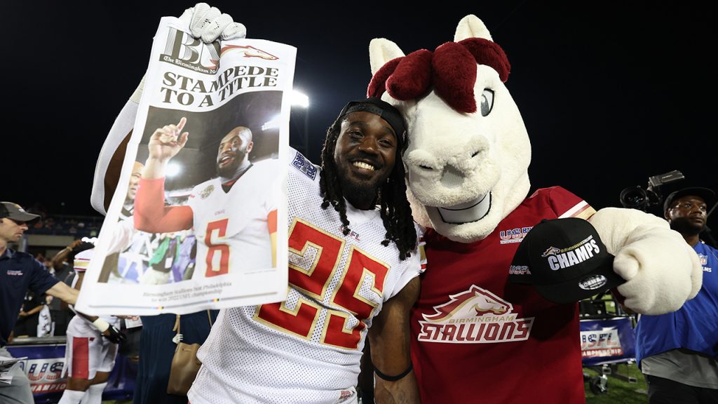 Bo Scarbrough #25 of the Birmingham Stallions poses with the Birmingham Stallions mascot after defeating the Philadelphia Stars 33-30 to win the USFL Championship game at Tom Benson Hall Of Fame Stadium on July 03, 2022 in Canton, Ohio.