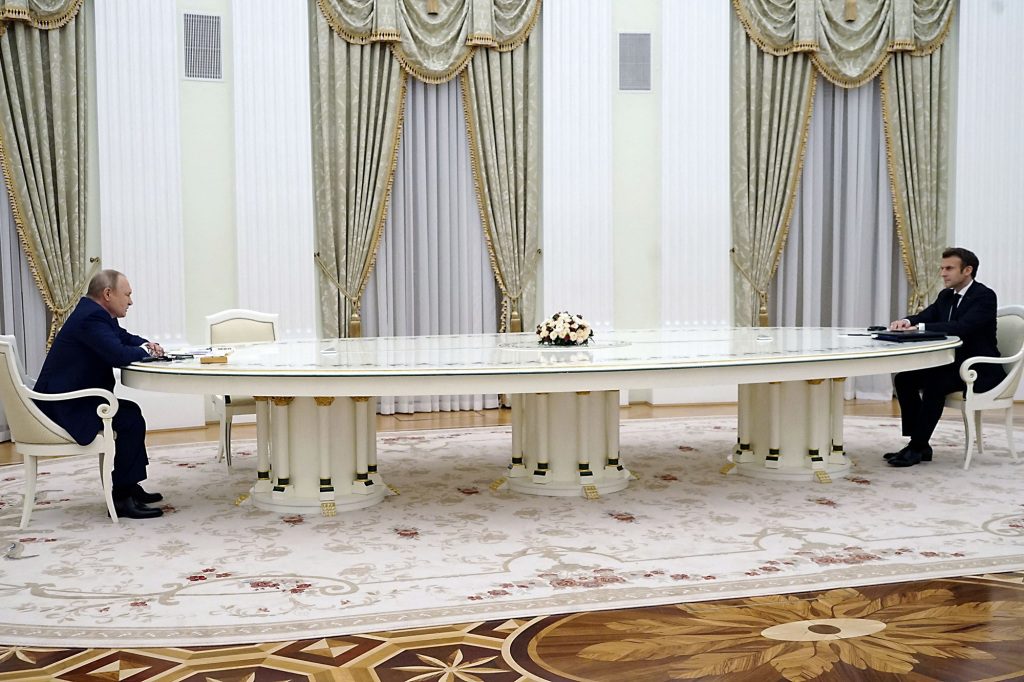 Putin und Marcon sitzen sich an einem Tisch in Moskau gegenüber