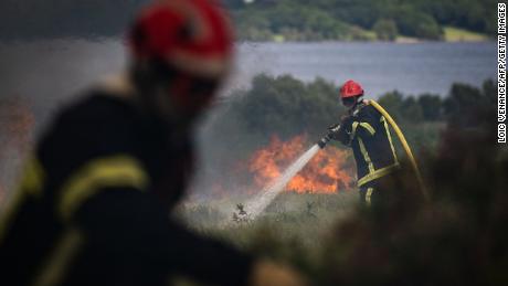 Feuerwehrleute sprühen Wasser über einem Großbrand in Monts d'Arey in der Bretagne im Nordwesten Frankreichs.