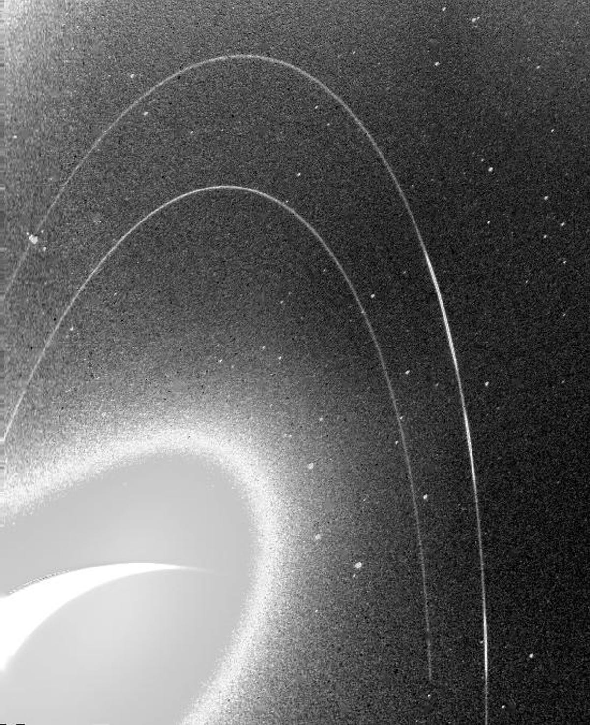 Das körnige Schwarz-Weiß-Bild zeigt die schwachen Ringe von Neptun.